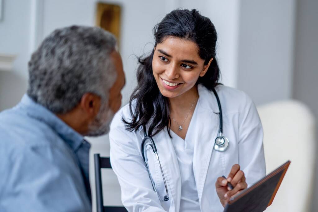 A doctor engages in a conversation with a patient, providing guidance and support in a clinical setting.