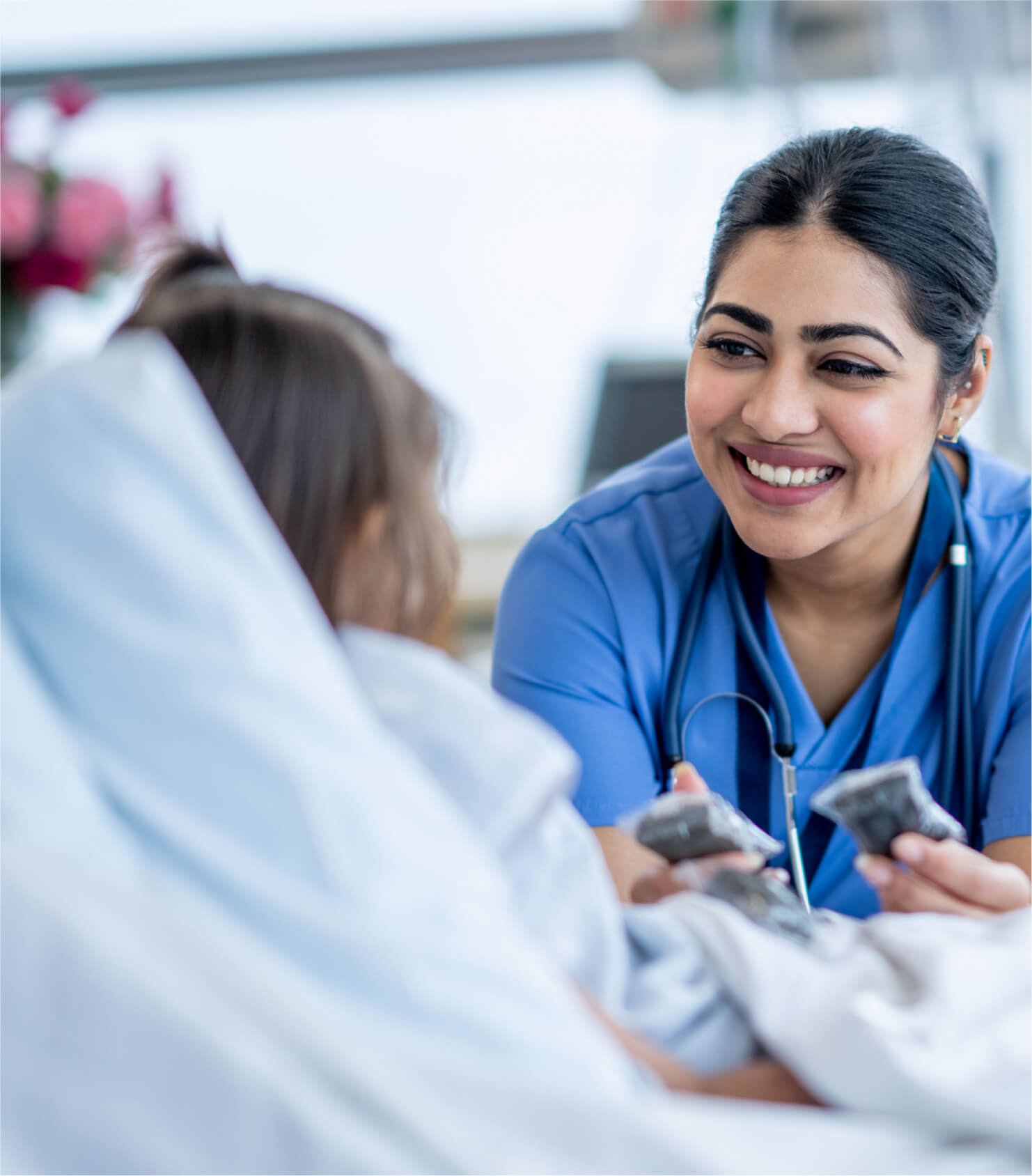 Female nurse smiling at young patient on a medical bed