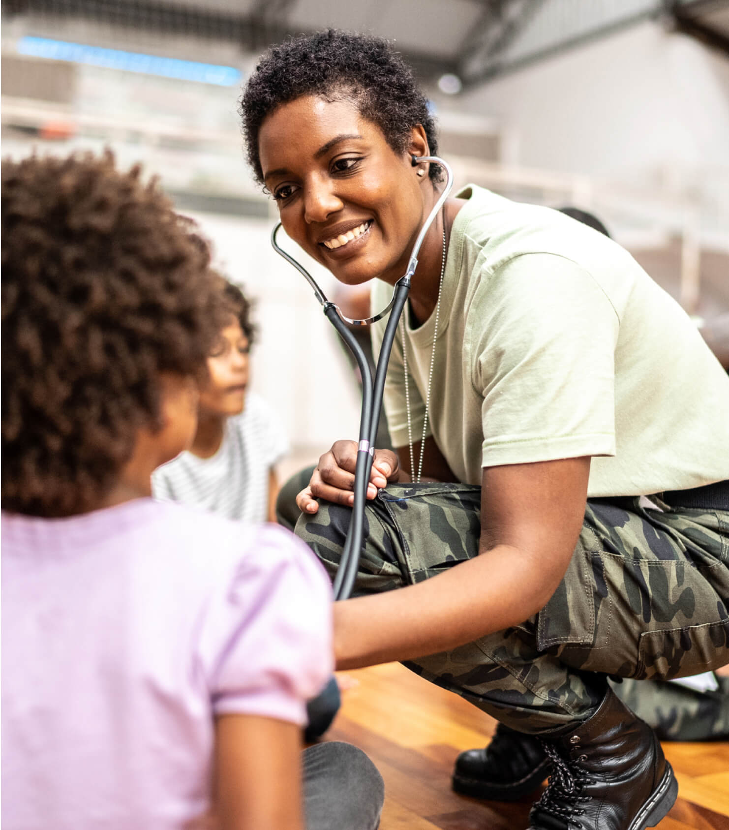 Military nurse listening to a childs heartbeat with stethoscope